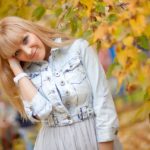 Piękna pani blondynka obok drzewa